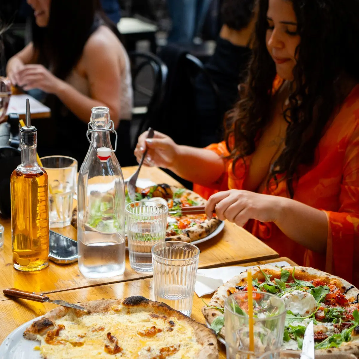 table avec une cliente et des pizzas