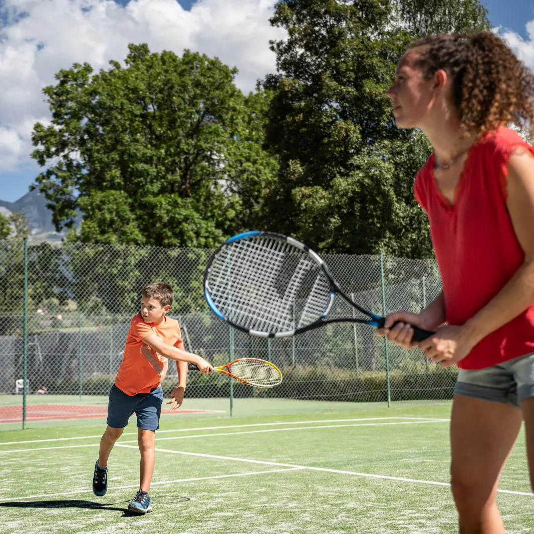 photo d'un enfant et d'une femme en train de jouer au tennis