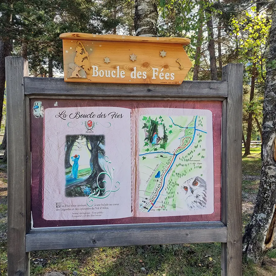 Panneau d'information au départ de la randonnée dans une forêt, inscription La Boucle des Fées