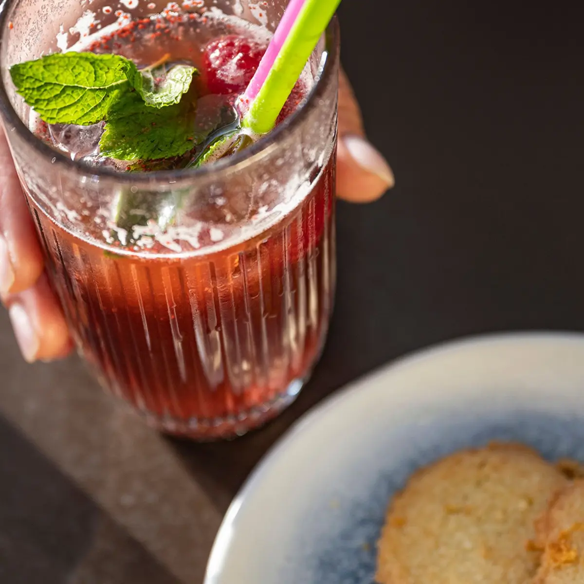 boisson te,ue dans la main et gateau salée dans une assiette gros plan