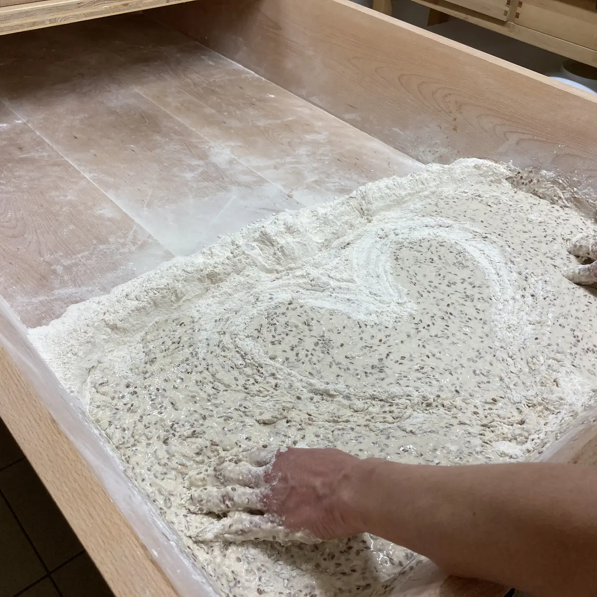 Pétrissage à la main dans le pétrin en bois