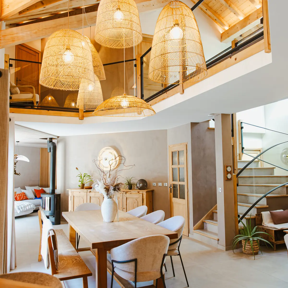 Salle à manger avec plafond haut et plusieurs luminaires suspendus