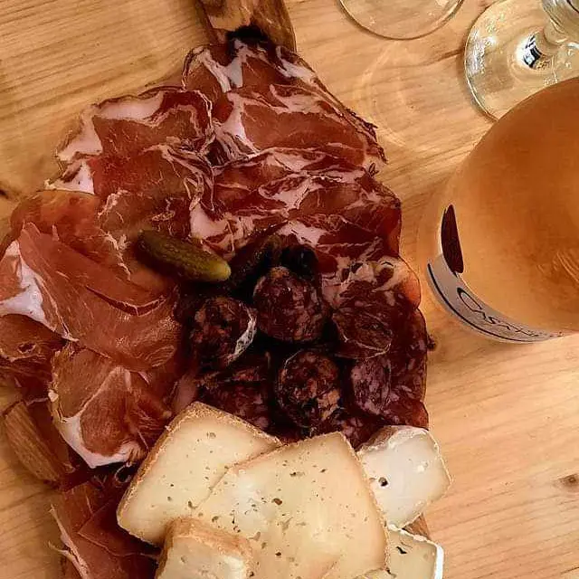 Planche à découper en forme d'île de Corse avec charcuterie, fromage, olive et basilic