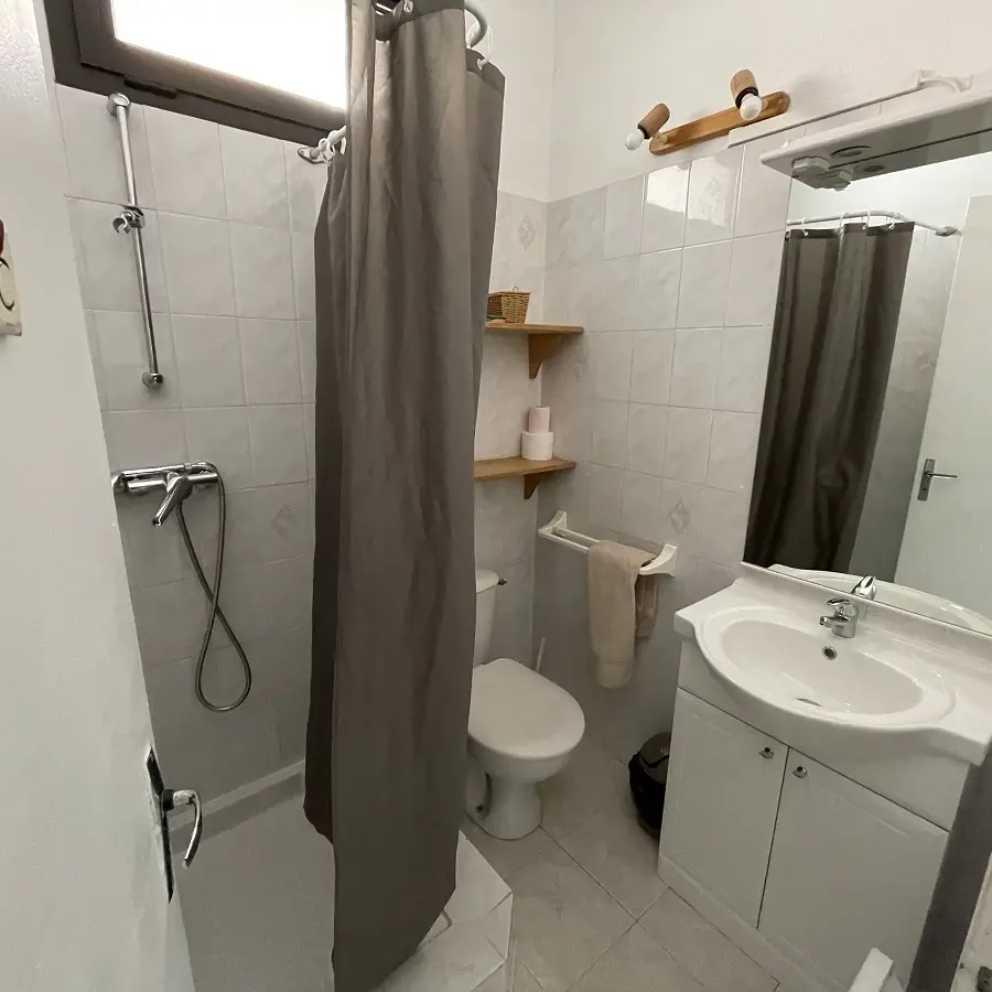 Salle de bains carrelée lumineuSalle de bains carrelée lumineuse avec bac à douche, fenêtrese avec bac à douche