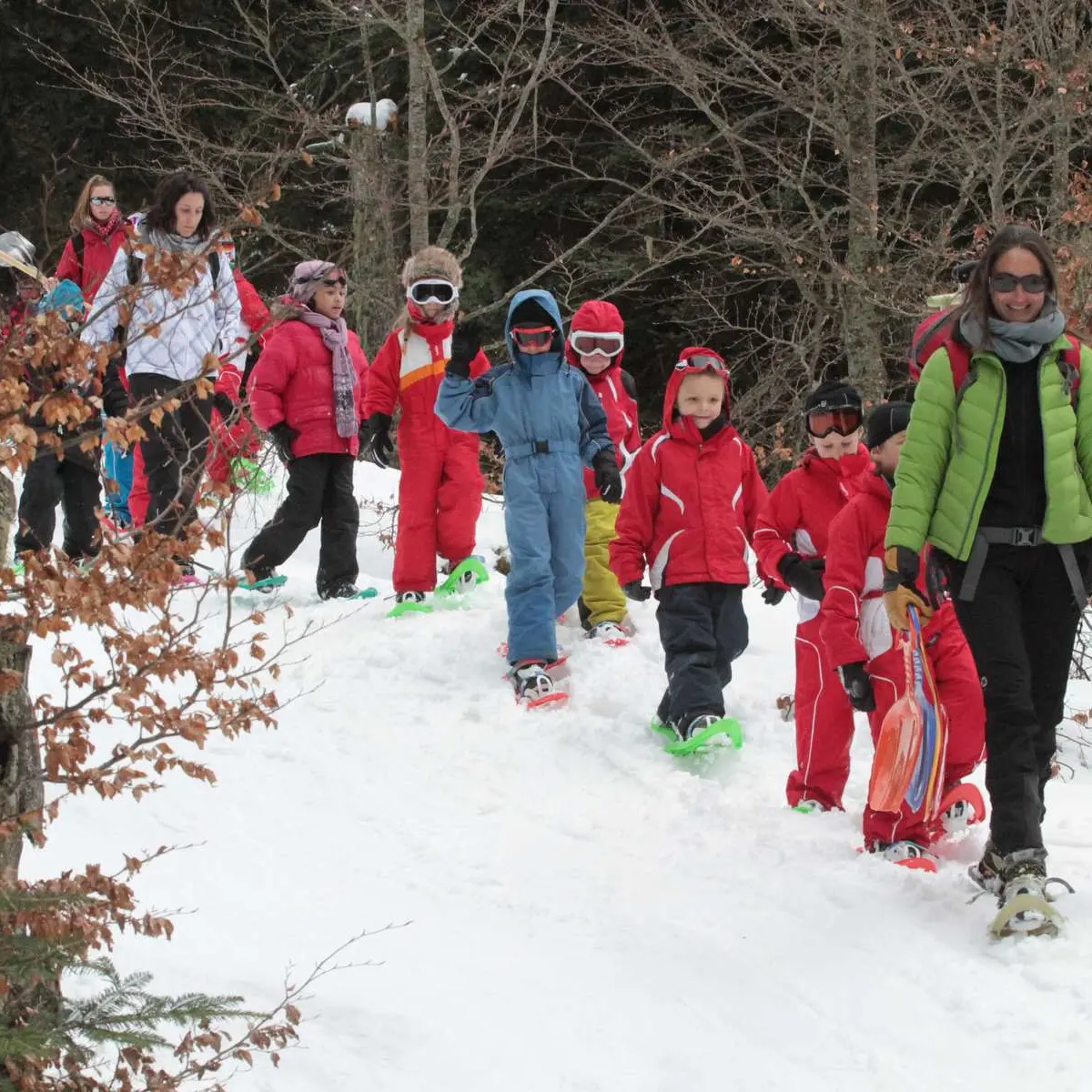 enfants à raquettes avec accompagnatrice en montagne