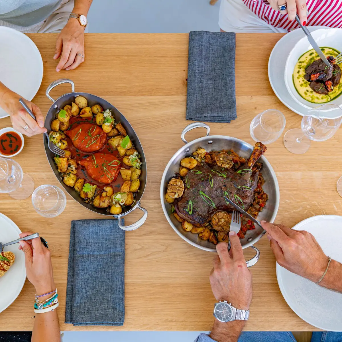 4 personnes a table qui partagent des plats