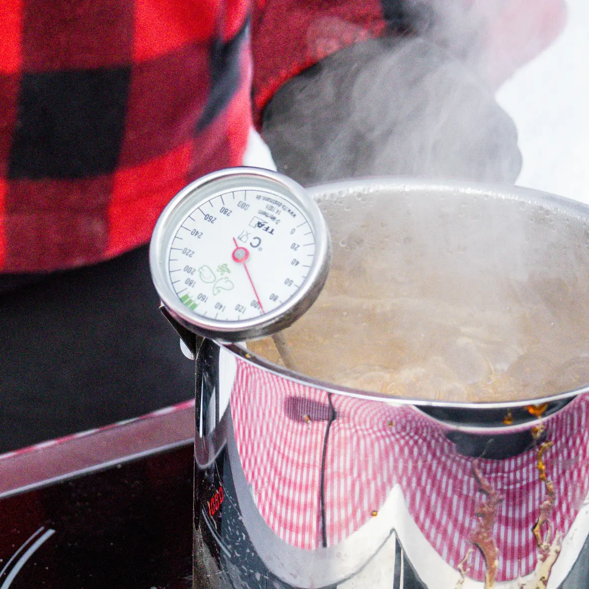 .On mesure la température du sirop qui bout dans une casserole. On verse ensuite le sirop chaud sur la neige pour en faire des bonbons.