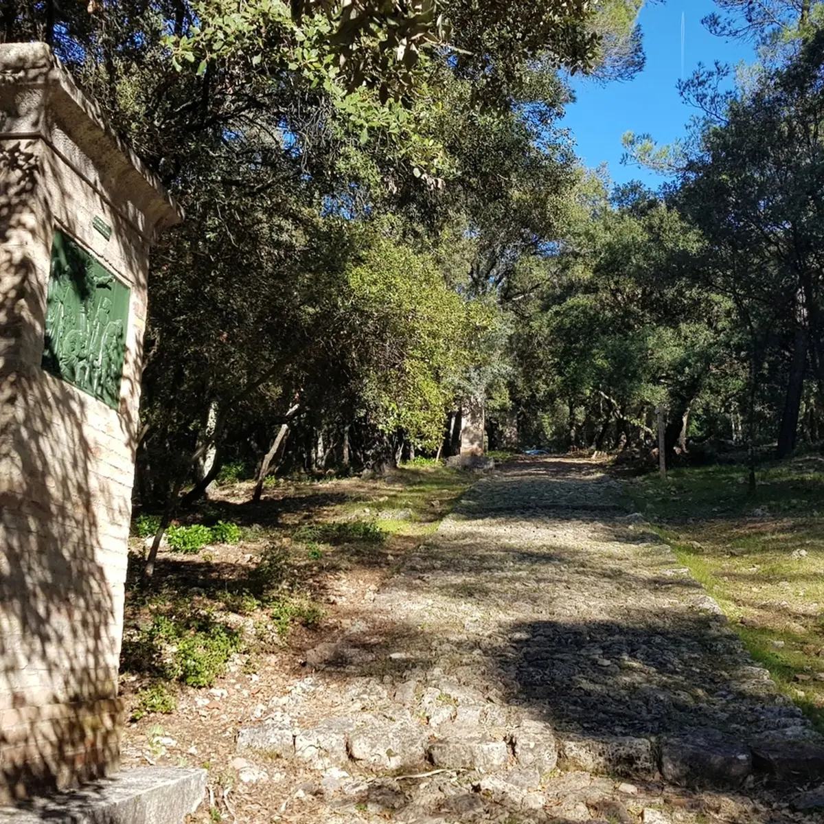 Vue sur les escaliers en pierre cheminant vers le sommet et un oratoire sur la gauche