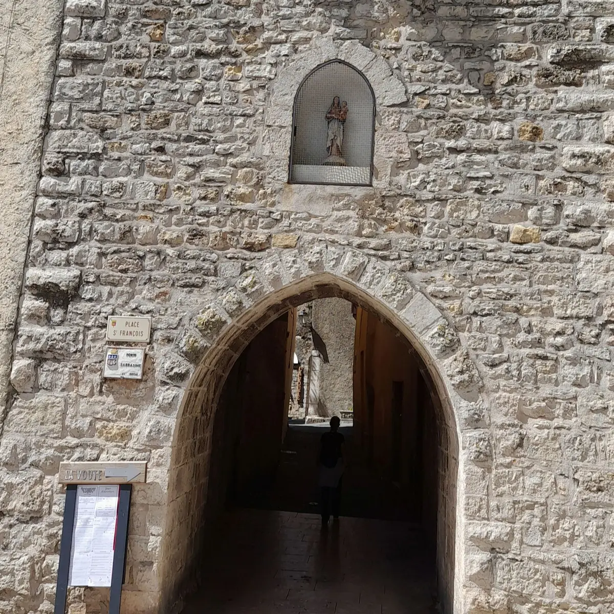 Porte sarrasine voutée surmontée d'une niche abritant une statue d'une vierge protectrice