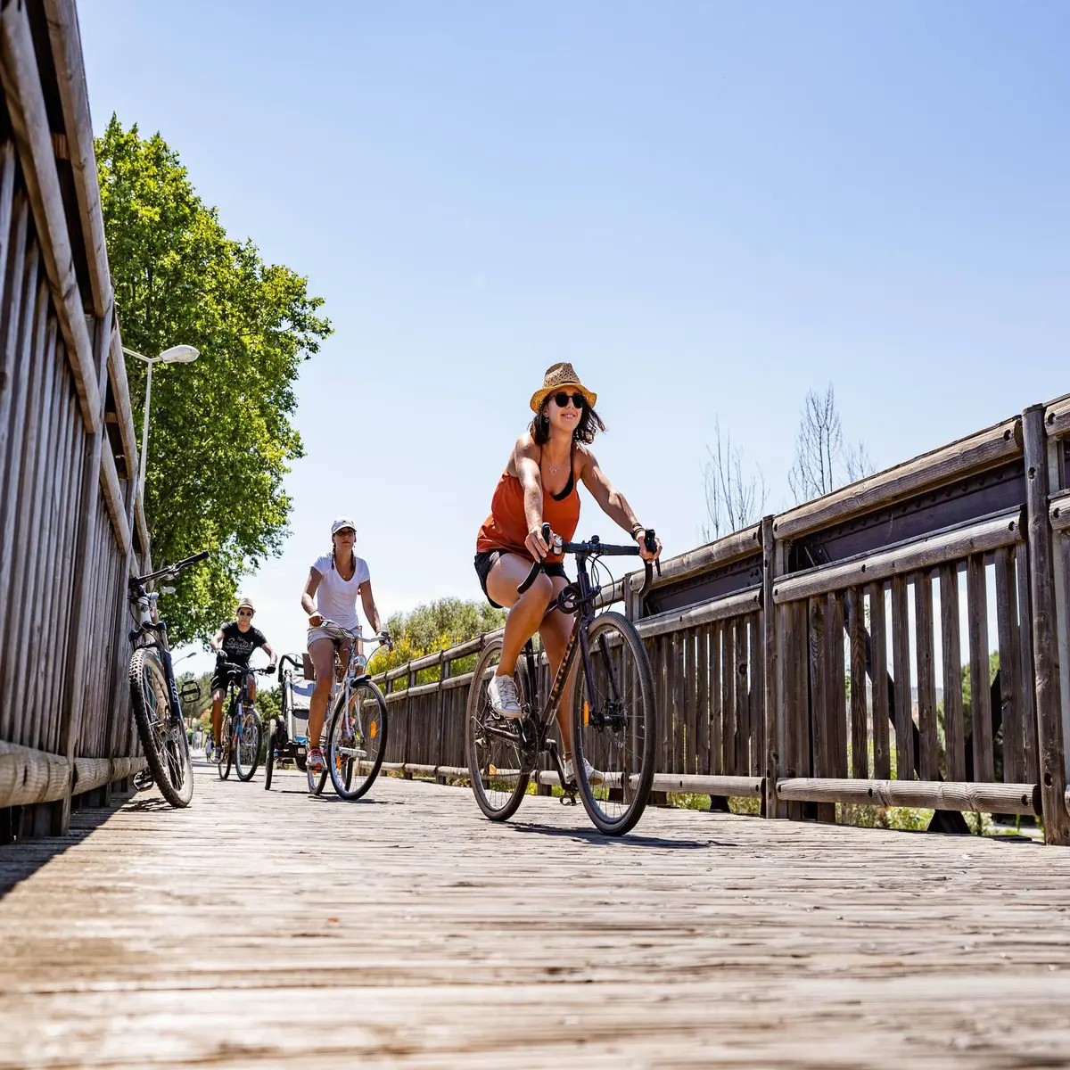 Petit groupe de cyclistes sur une passerelle en bois