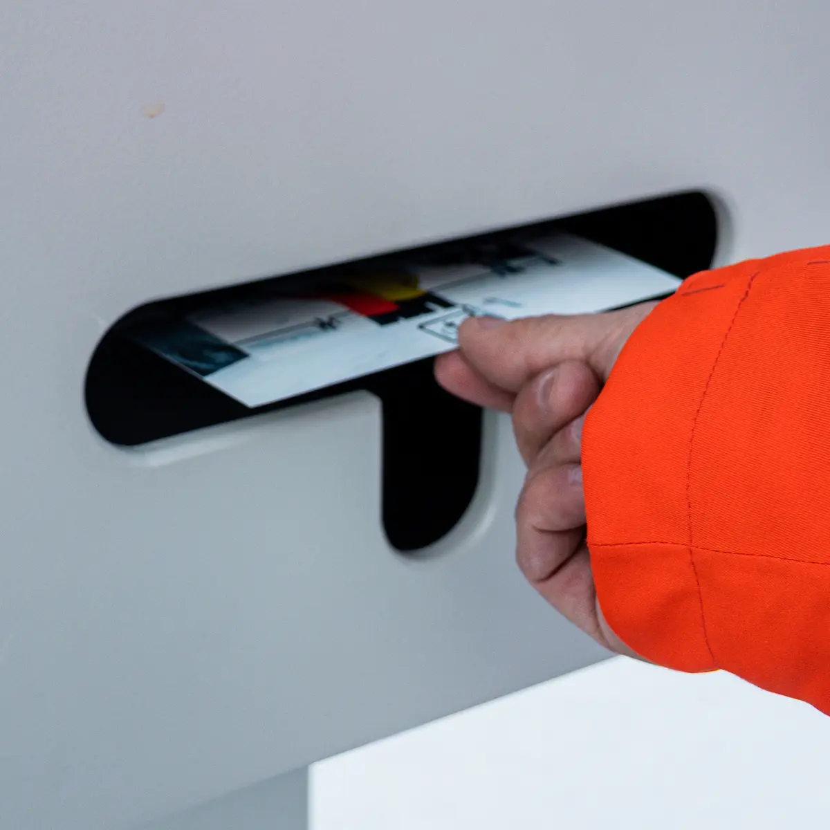 Une main sort une photo imprimée de la fente d'un photobooth