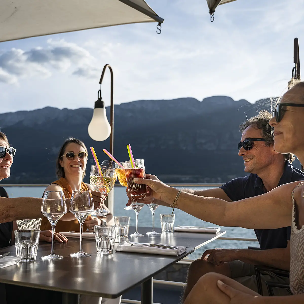 amis à l'apéritif sous parasol vue sur le lac d'annecy