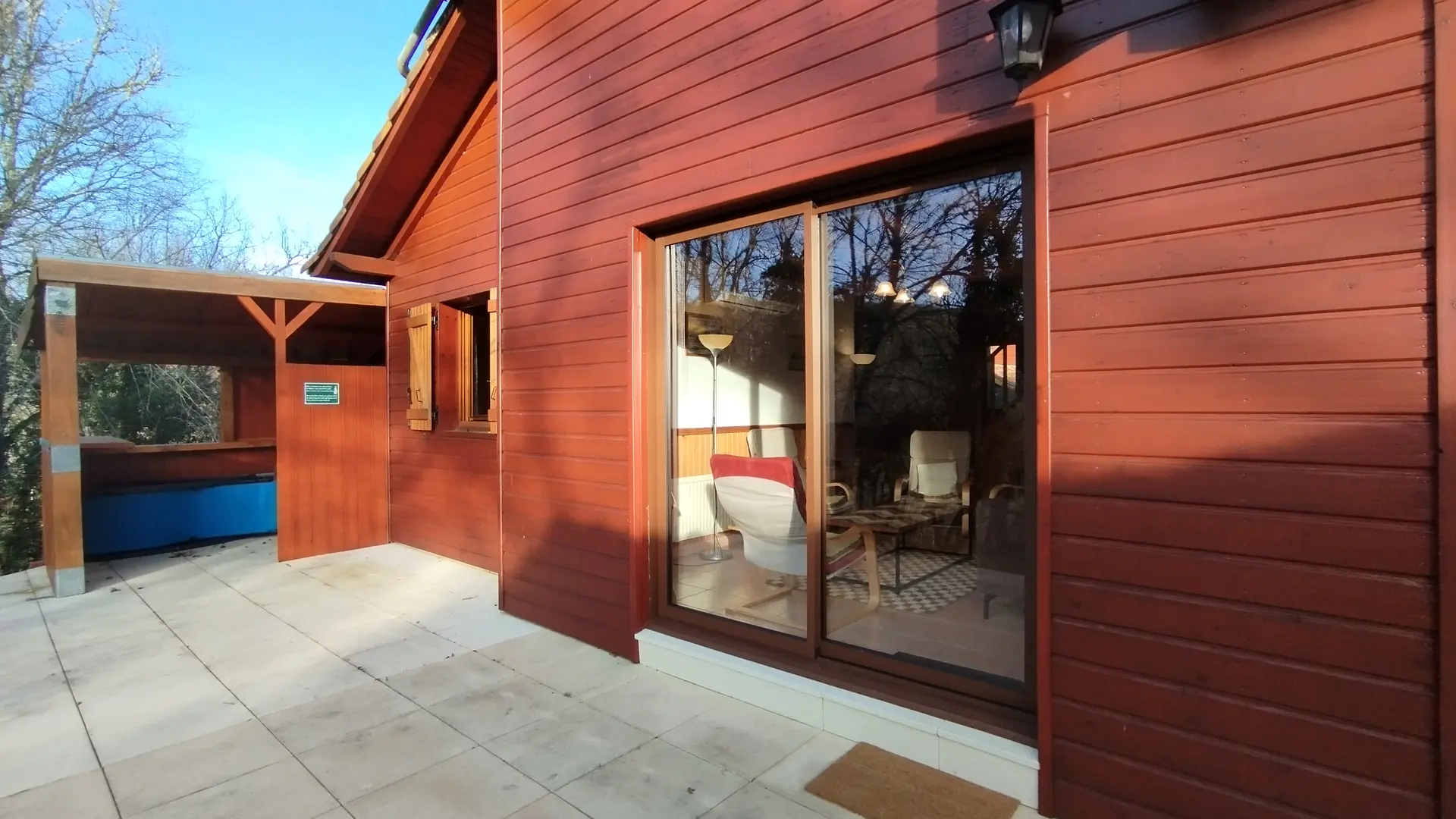 Porte-fenêtre du salon donnant sur terrasse arrière