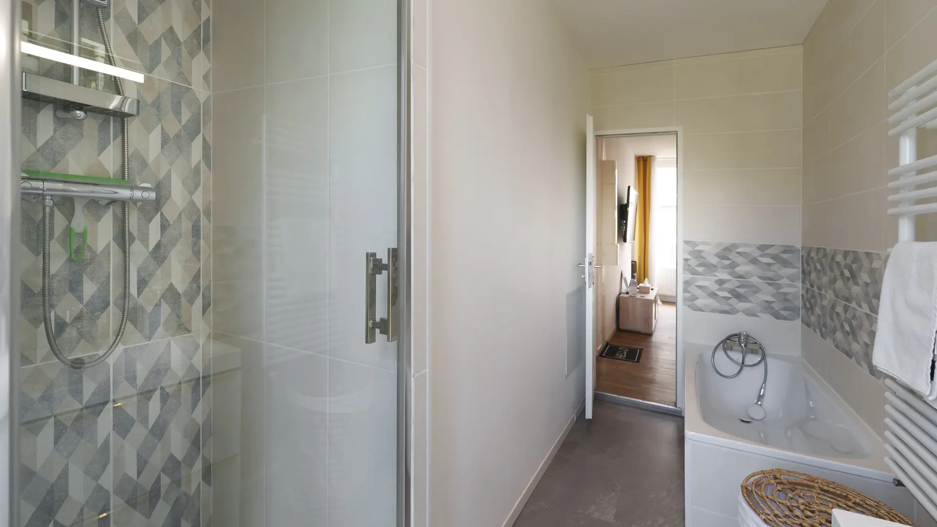 Grande salle de bain avec douche et baignoire