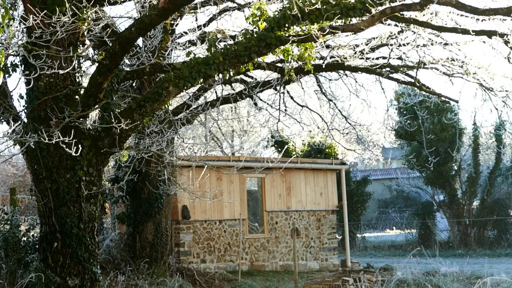 Cabane bois cordé sous les chênes