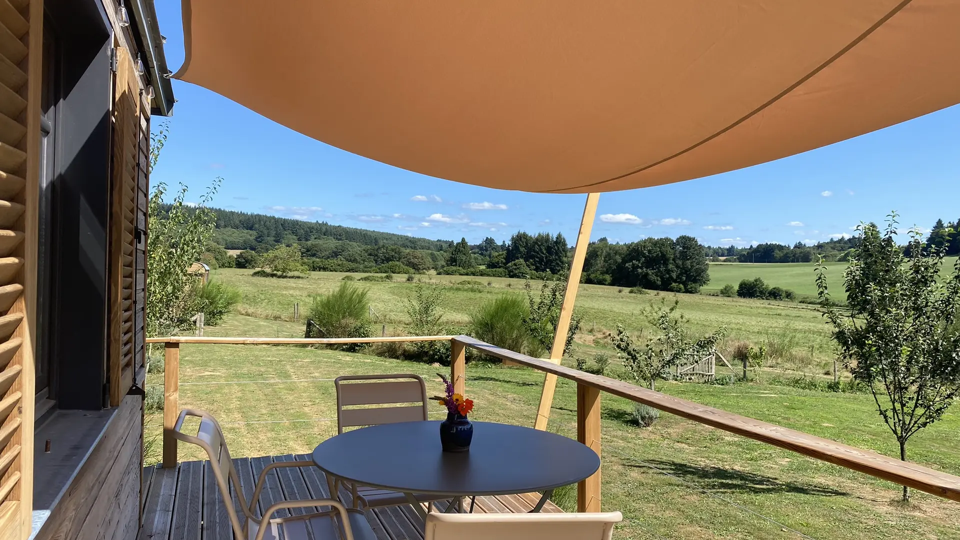 Roulotte du Verger et sa terrasse plein sud donnant sur la nature.