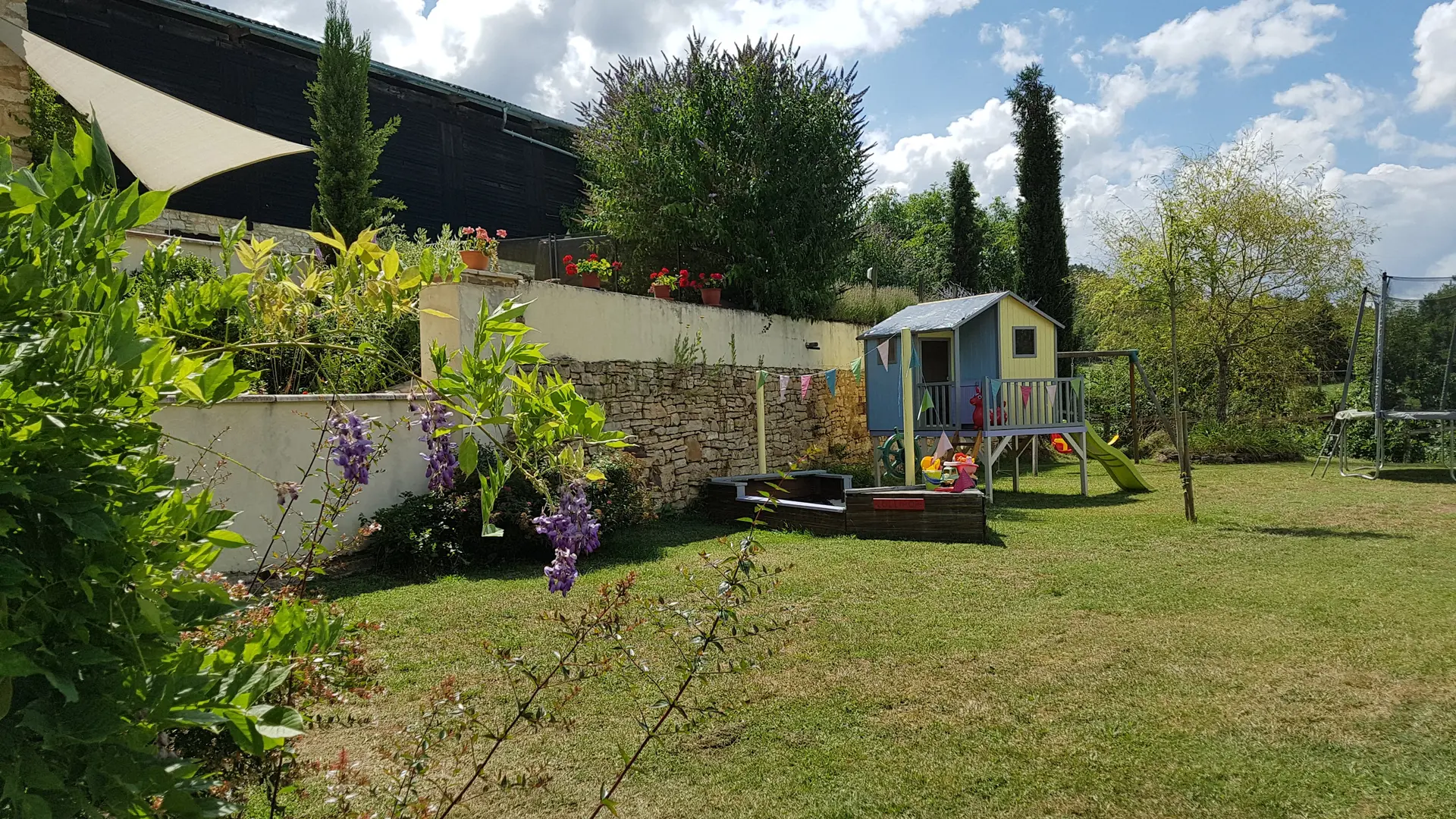 Jardin avec bac a sable, trampoline et maisonette