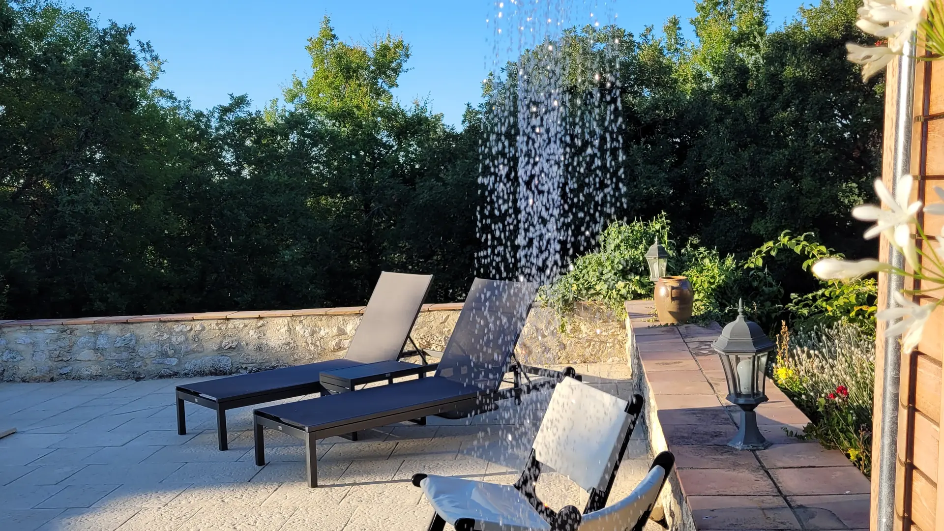 Terrasse de piscine avec transats et douche extérieure