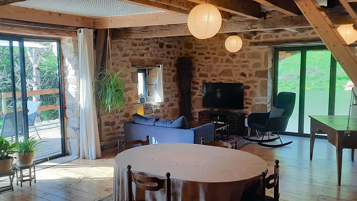 La pièce de vie avec son espace salon, smart TV, bureau et accès à la terrasse.