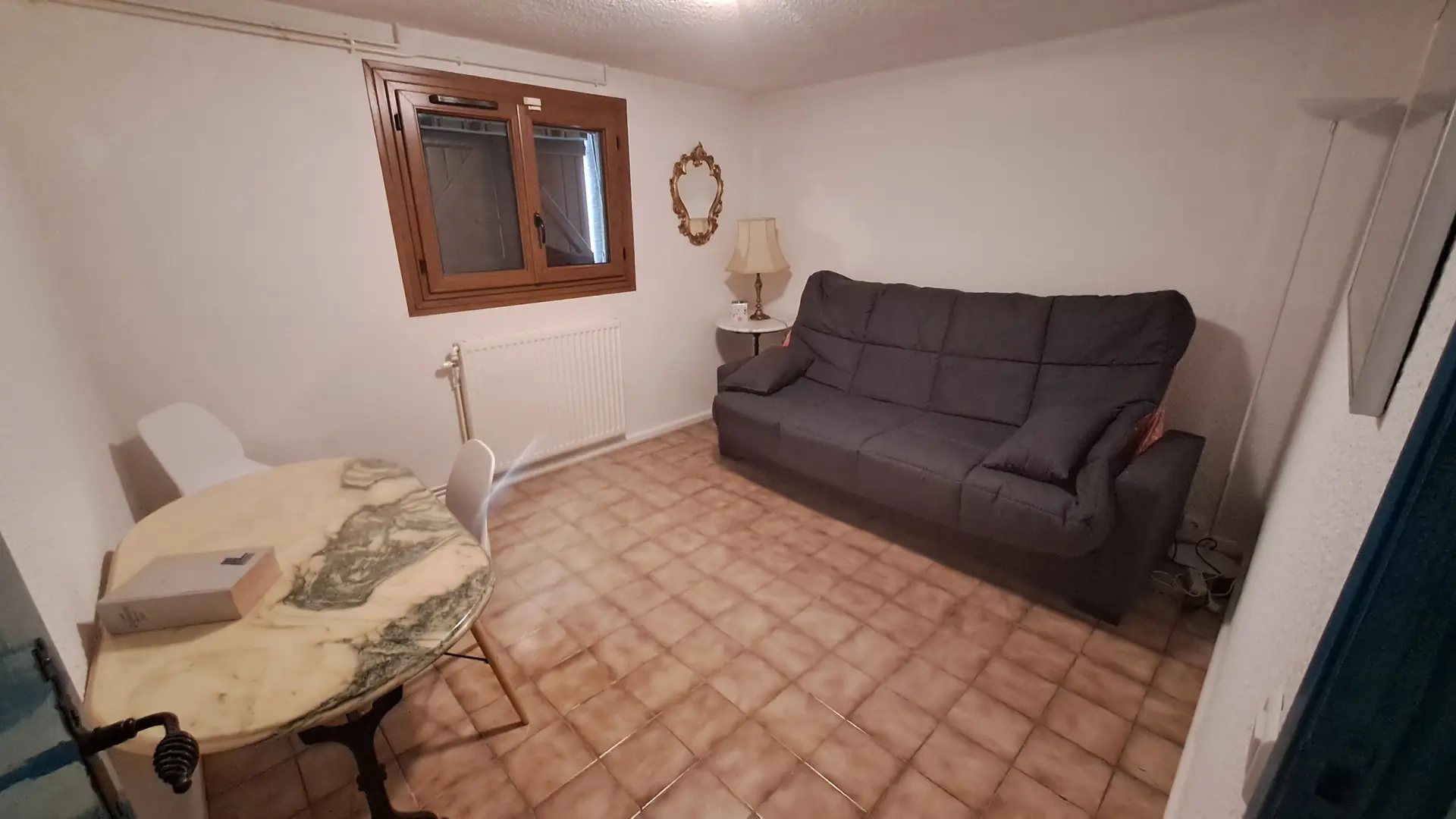 Sous-sol pièce avec clic clac, douche et WC à proximité