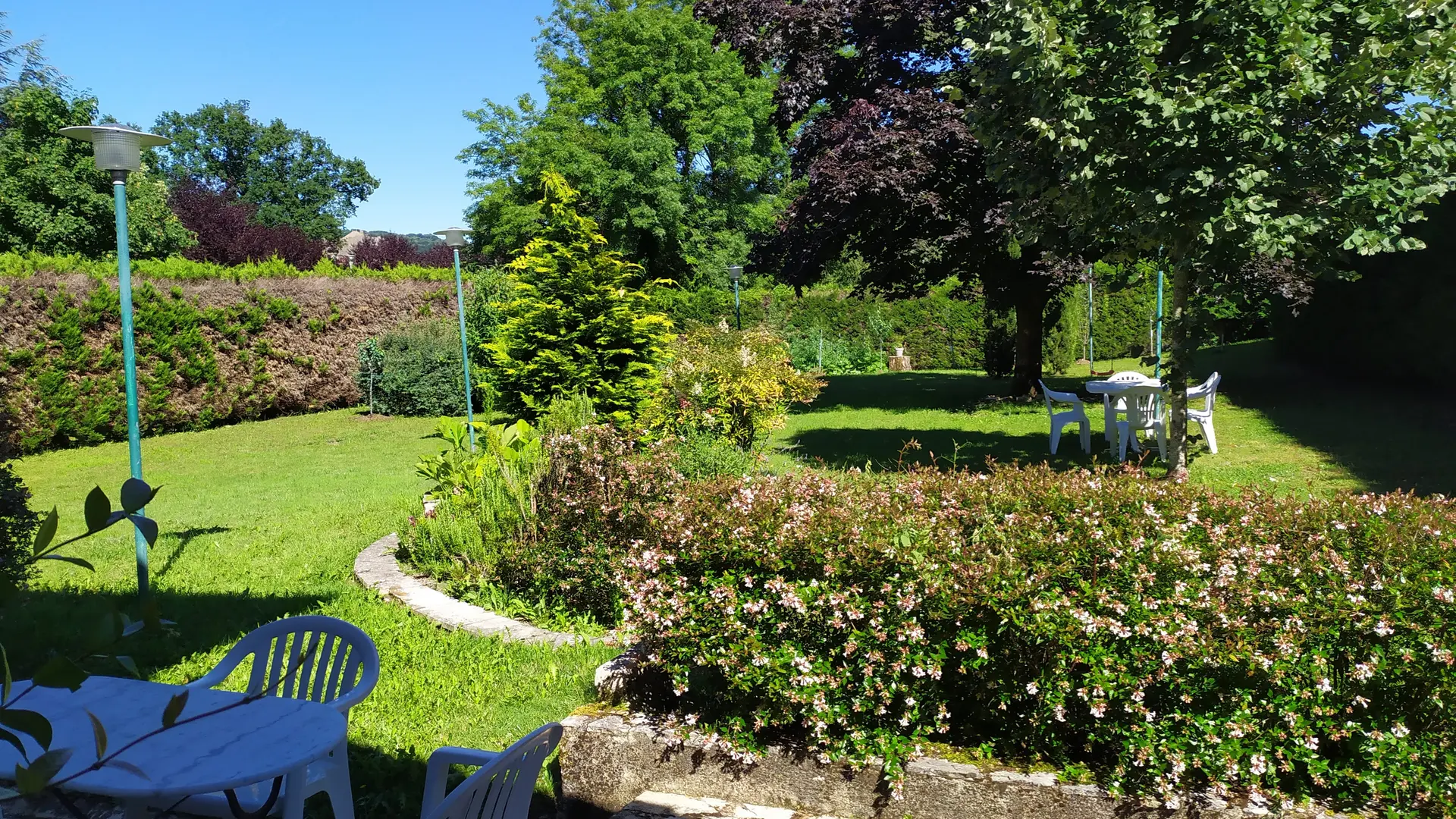 Jardin avec terrasse équipée d'une table bistrot, 1 banc et 3 fauteuils