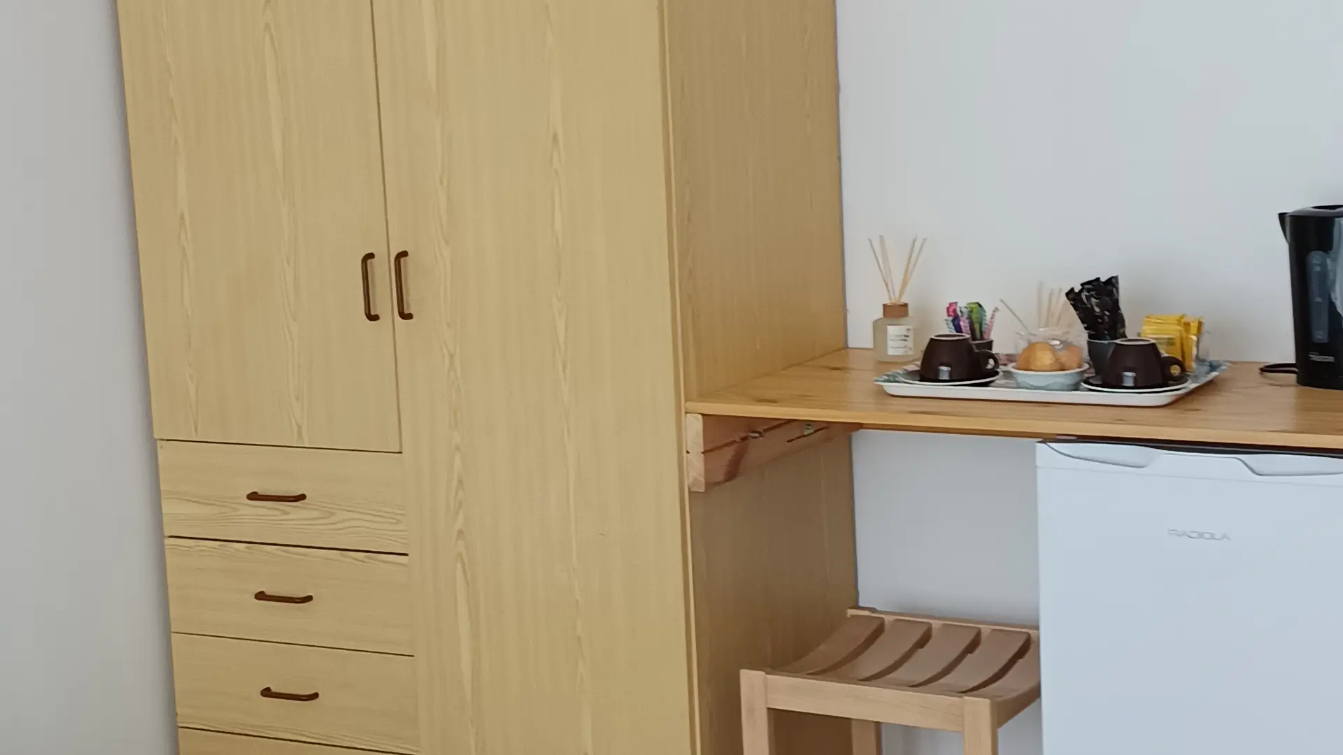 Rangement de la chambre avec frigo et table petit dejeuner