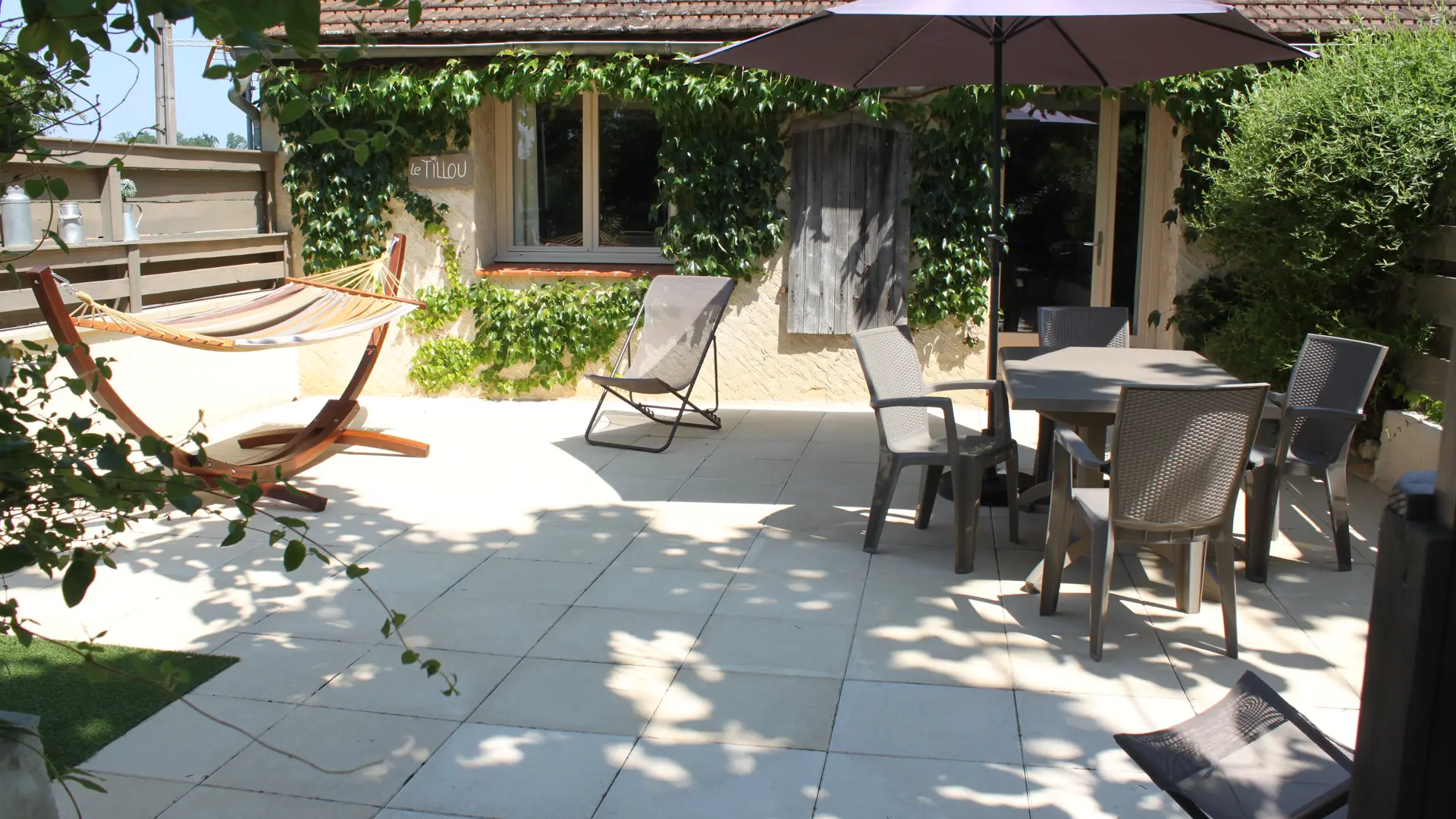 La grande terrasse privée en pierre du gite, avec hamac.