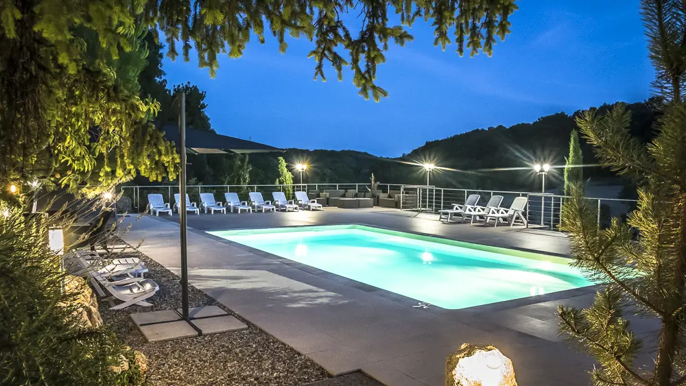 La piscine avec sa grande plage et ses nombreux transats