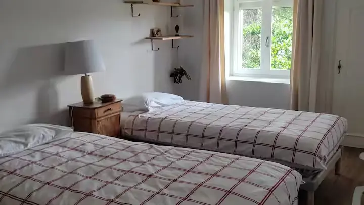 Première chambre, deux lits une place, vue sur le jardin