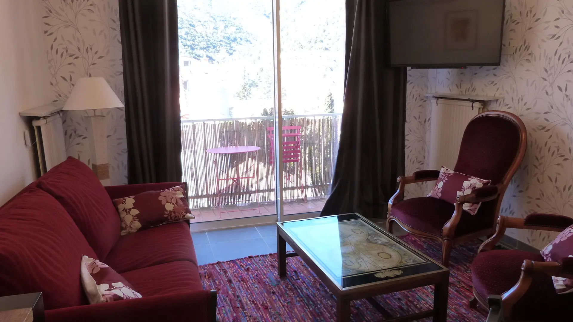 ° salon avec canapé, deux fauteuils, et grand écran plat 4K