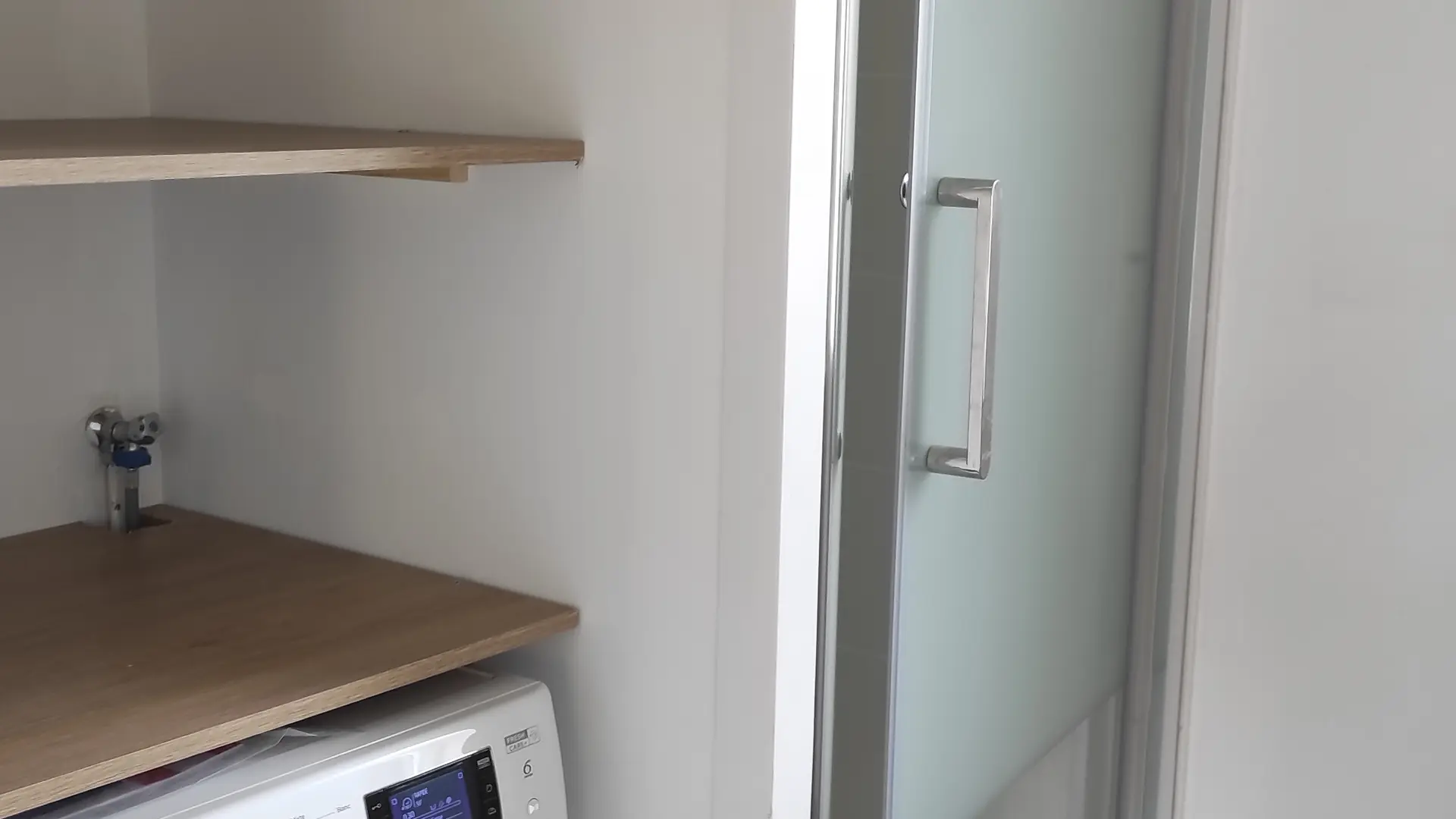 salle de bain avec douche et machine à laver