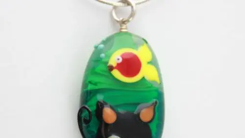 Pendentif perle en verre avec chat et poisson.