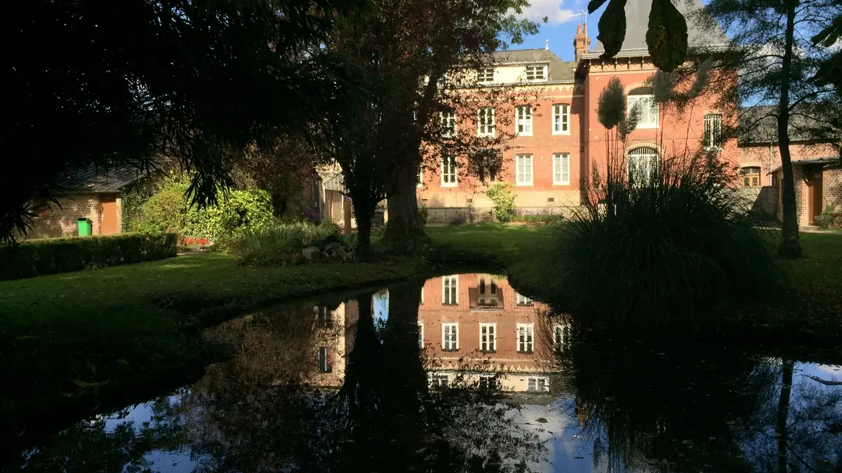 La maison du parc se reflétant dans le plan d'eau