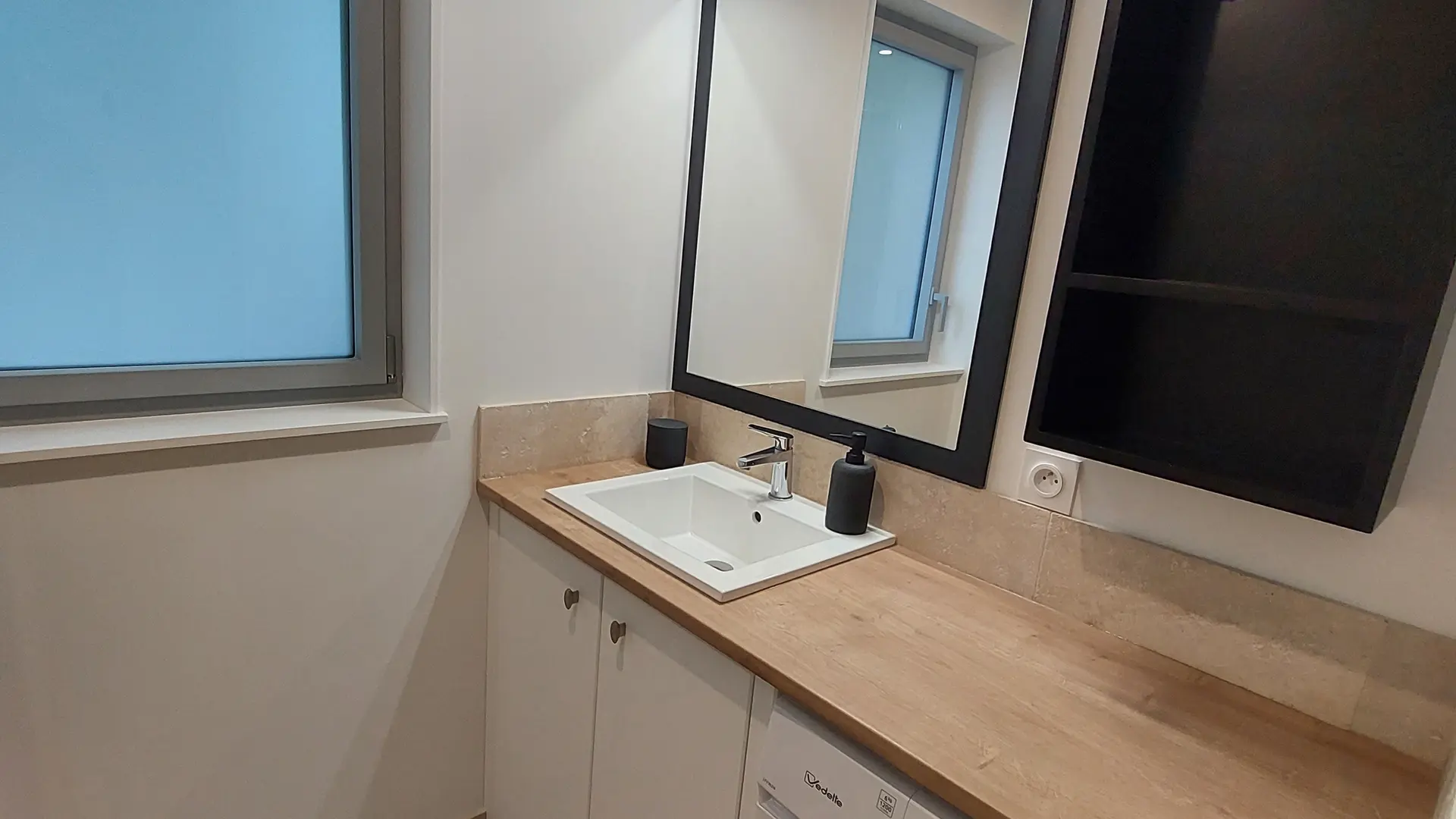 Salle d'eau avec lavabo et lave linge