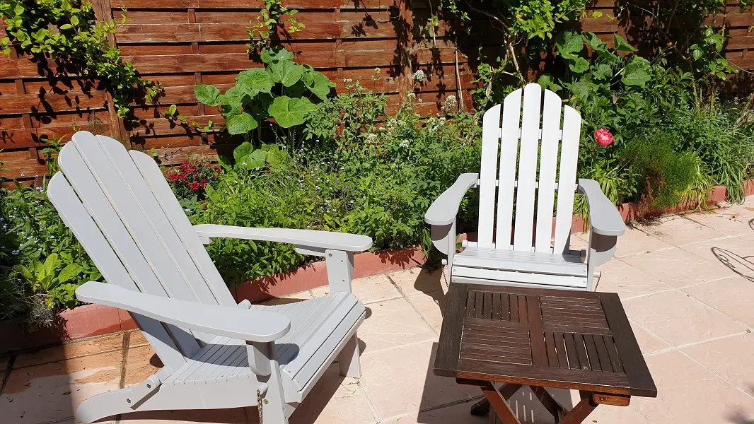 Chaises-longues dans le jardin, avec plantes aromatiques.