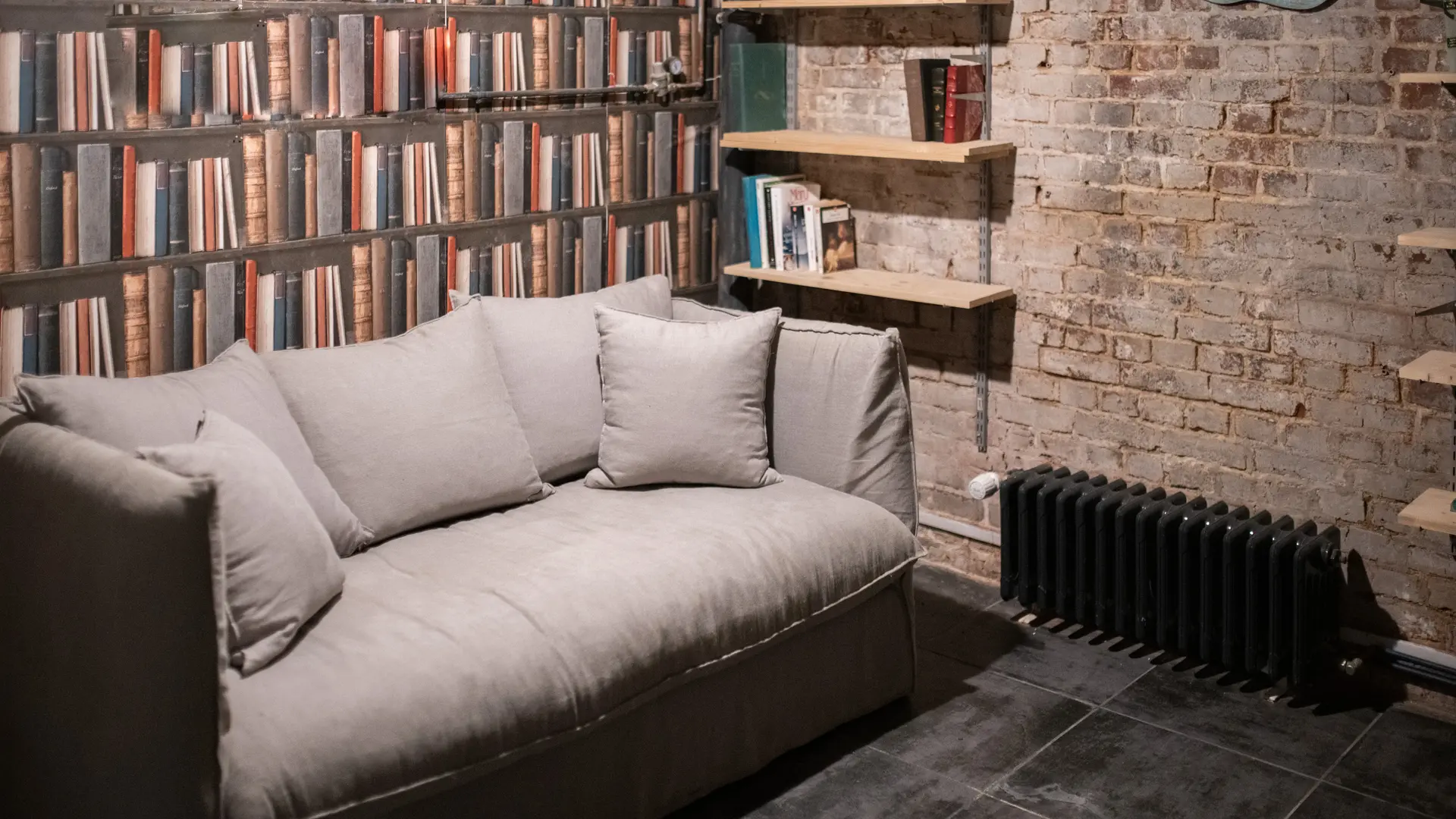 Sous sol aménagé avec canapé lit et coin lecture