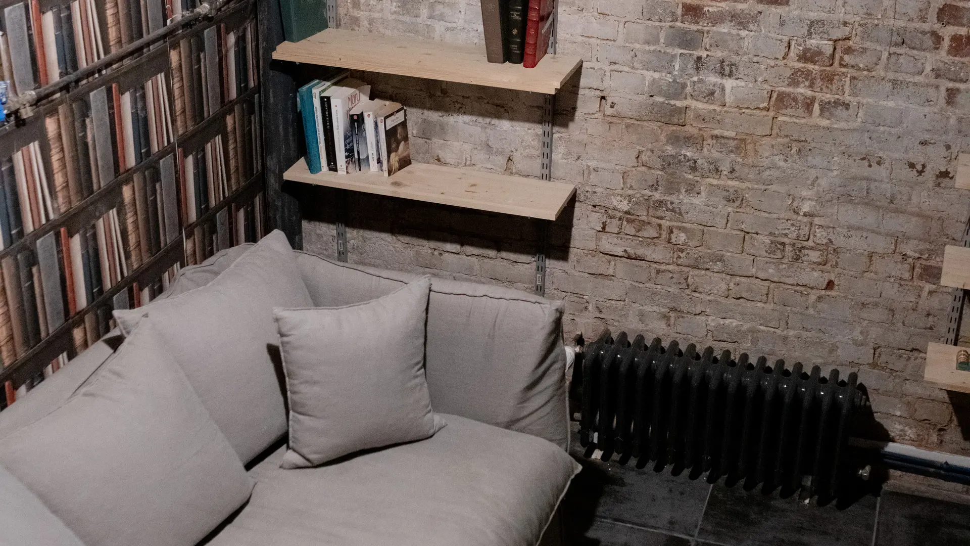 Sous sol aménagé avec canapé lit et coin lecture