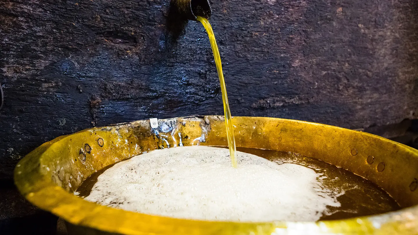 L'huile coulant du pressoir au Moulin de la Veyssière à Neuvic