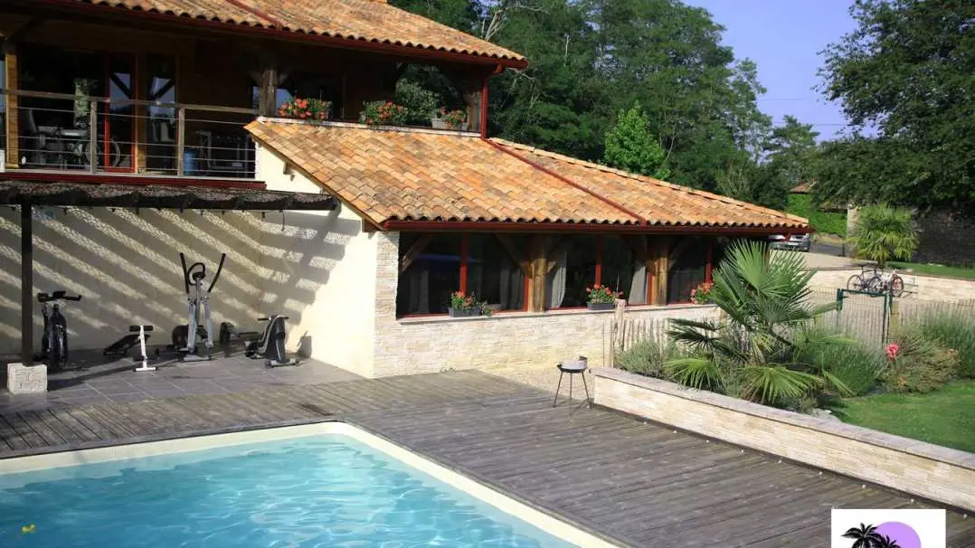 la piscine avec le gîte au rez-de-chaussée