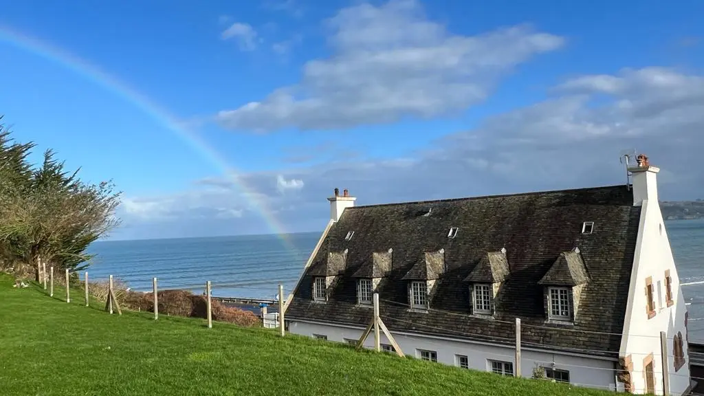 Maison vue arrière mer arc en ciel