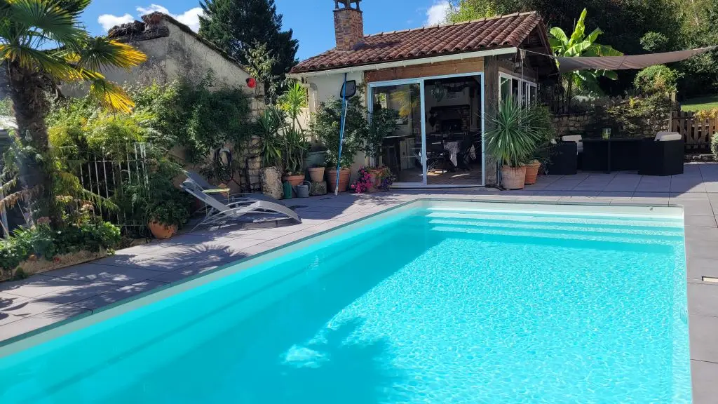 la piscine avec en fond la cuisine d'été du gite Pierre Forte