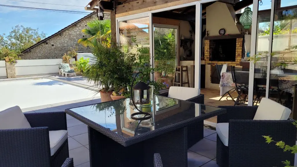le salon de jardin avec vue sur la piscine et la cuisine d'été du gite Pierre Fo