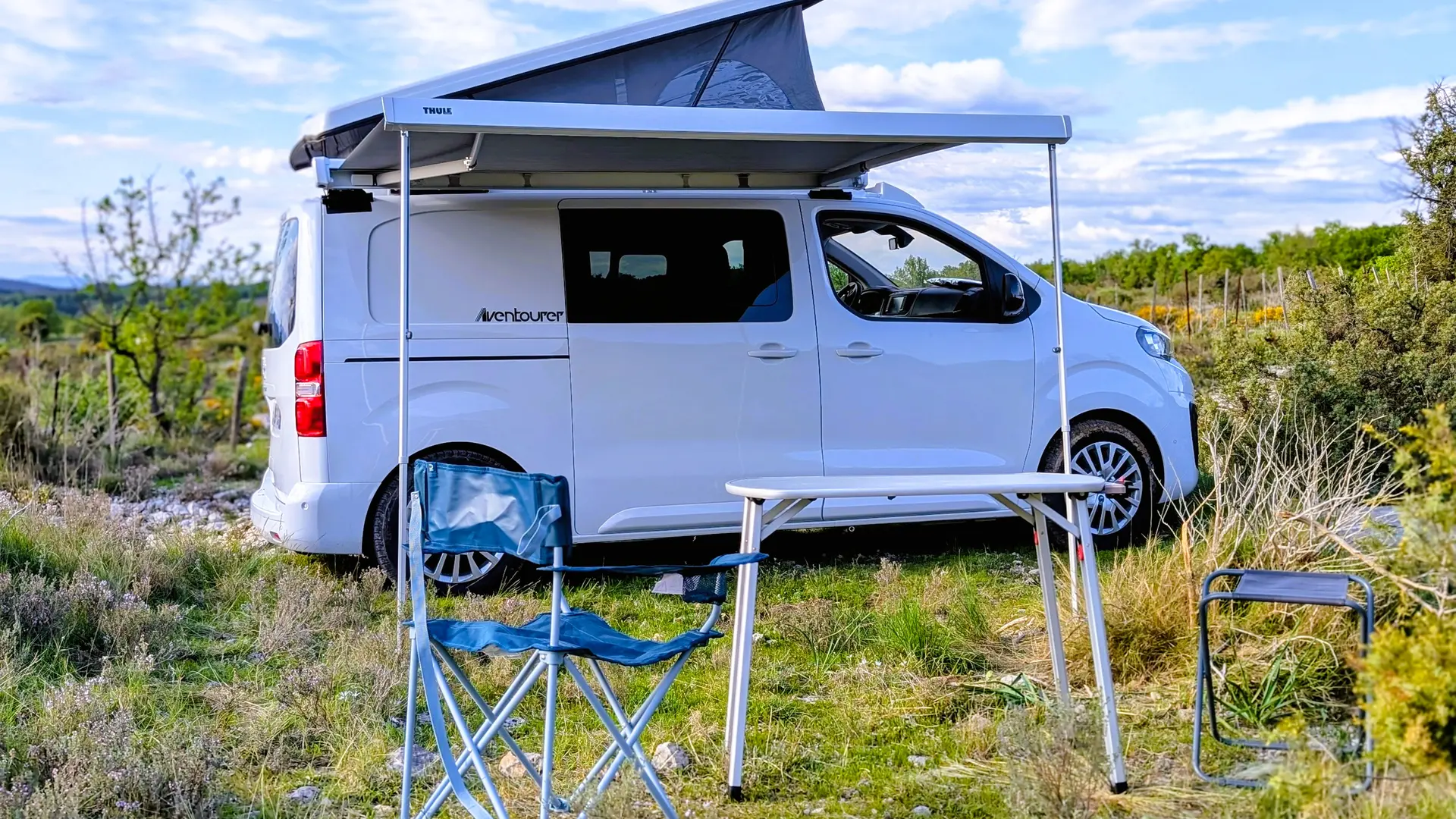 van_amenage_peugeot_aventourer_gvan_location_montpellier_installe_paysage_table_et_chaises_sorties_contraste_chaud