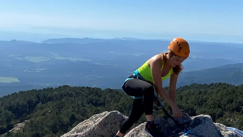 Femme en escalade avec vue panoramique de la foret et côte