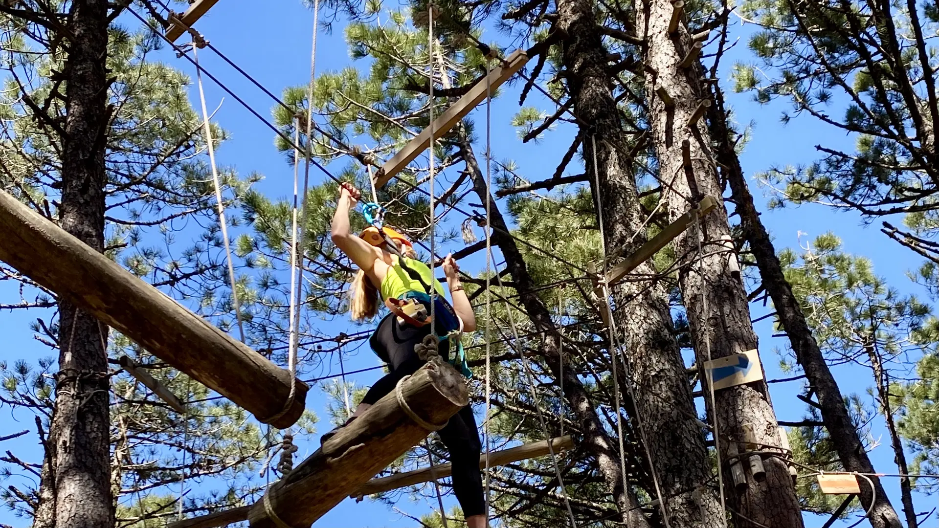 Photo d'une femme pendant un parcours d'accrobranche au cœur de la forêt de l'Ospedale