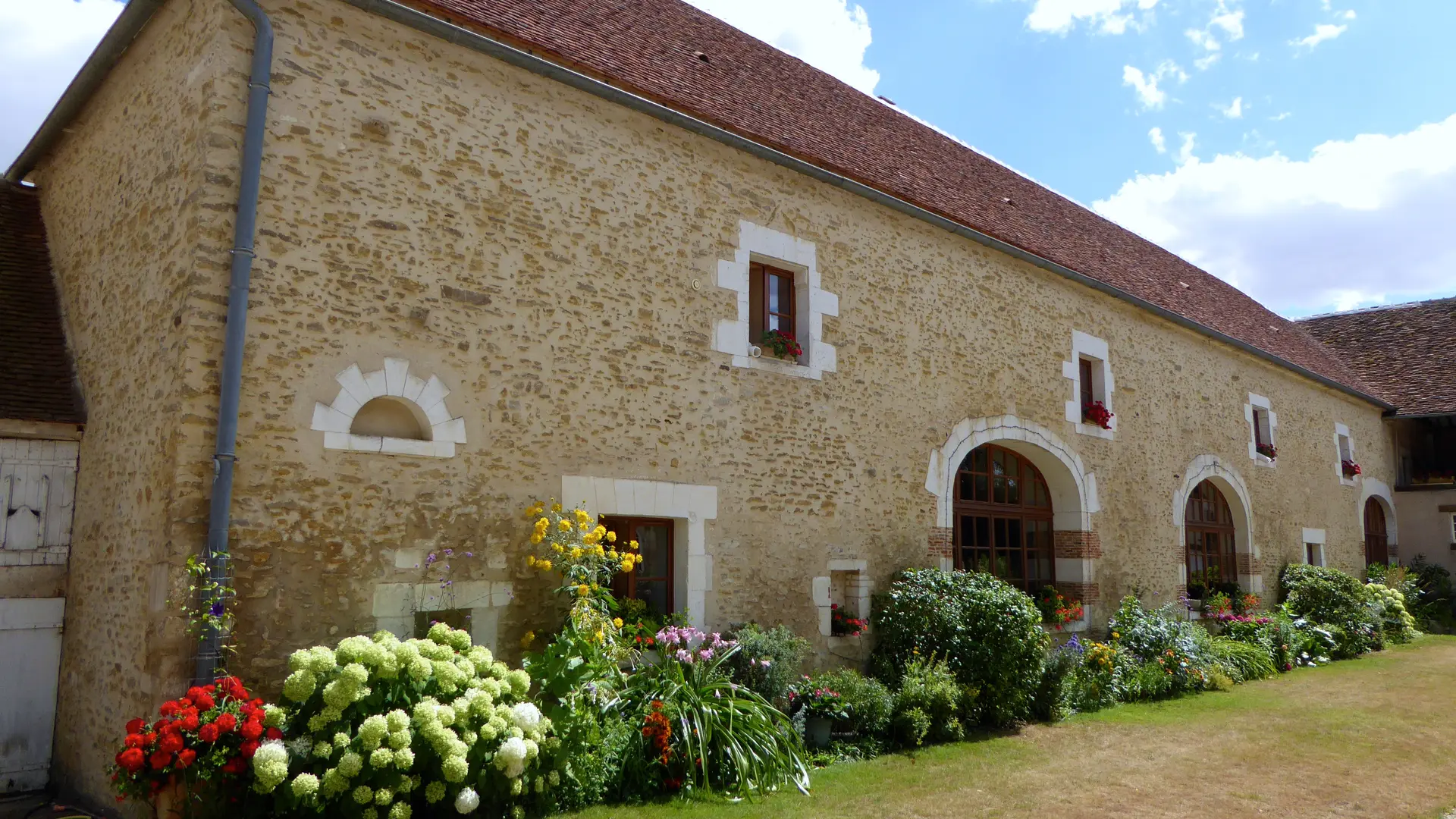 Façade fleurie des Granges du Château - Gîte 14 personnes en Puisaye