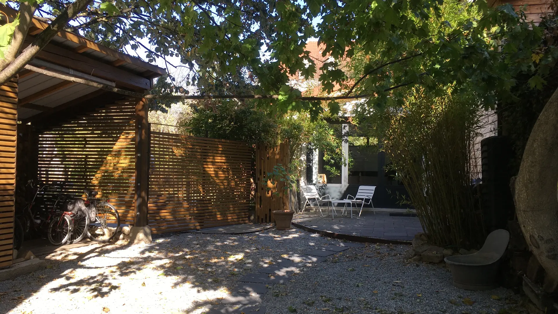 Entrée privative. Cour arborée et abri vélo.