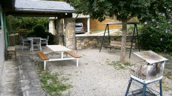 Gîte le Cigalon cour close avec barbecue, balancelle et vue abri voiture