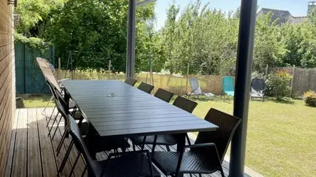 La terrasse couverte est vraiment une pièce supplémentaire aux beaux jours, accessible depuis la cuisine et le salon.
12 places à table comme à l'intérieur. On peut y profiter du jardin tout en étant à l'abri du soleil et de la pluie !