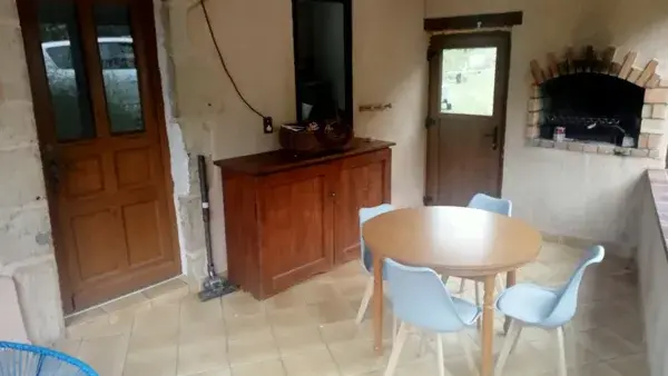 Véranda et sa cheminée où vous pourrez manger et cuire vos grillades